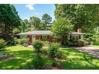 Charming brick ranch home with lush landscaping and inviting front entrance at 2008 Kimway Dr, Matthews, NC 28105