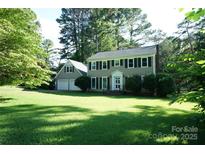 Charming two-story home with a well-manicured lawn and lush trees creating a picturesque setting at 2087 Poinsett Dr, Rock Hill, SC 29732