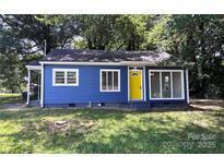 Charming blue house with a vibrant yellow door and well-maintained front yard at 218 Hartman St, Gastonia, NC 28052