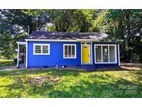 Charming home showcasing its vibrant blue exterior, bright yellow front door, and well-maintained lawn at 218 Hartman St, Gastonia, NC 28052