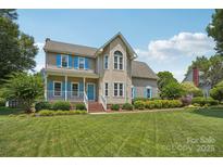 Charming two-story home with blue shutters, covered porch, and manicured lawn under a sunny blue sky at 2256 Drawbridge Ct, Rock Hill, SC 29732