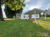 Quaint white home featuring a covered carport and a lush green lawn at 22987 Alonzo Rd, Oakboro, NC 28129