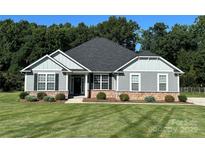 Charming single-story home with gray siding, black shutters, stone accents, and a well-manicured lawn at 231 Glenwood Dr # 4, Oakboro, NC 28129
