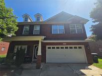 Charming two-story brick home with a two-car garage and a well-manicured front yard under a bright blue sky at 2476 Glyncastle Way, Gastonia, NC 28056
