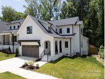 New construction home with a modern farmhouse style, gray garage, and well manicured lawn at 3953 Plainview Rd, Charlotte, NC 28208