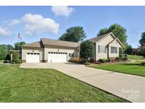 Charming home featuring an attached three-car garage and a well-manicured lawn at 402 Walnut St, China Grove, NC 28023