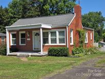 Charming brick home with a well-maintained front yard and cozy covered entrance at 412 Ridge St, Stanley, NC 28164