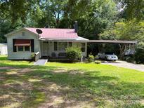 Charming house features a red roof, cozy front porch, carport, and wheelchair ramp access at 438 Faith Sw Dr, Concord, NC 28027
