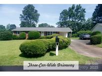 Charming one-story brick home with a well-maintained front lawn and an inviting three-car-wide driveway at 4429 Dawnwood Dr, Gastonia, NC 28056