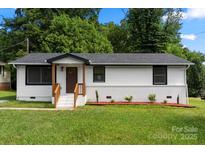 Charming ranch-style home with a well-maintained lawn, a brick foundation, and a welcoming front porch at 517 Dutch Ave, Mount Holly, NC 28120