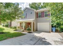 Charming two-story home with a stone-accented front porch, manicured landscaping, and a convenient attached garage at 5319 Swearngan Rd, Charlotte, NC 28216
