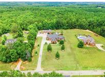 Expansive estate featuring multiple homes, lush greenery, and a private pool at 572 W Shiloh Unity Rd, Lancaster, SC 29720