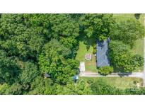 An aerial view of a home surrounded by lush trees in a serene, wooded neighborhood at 5914 Mt Holly Huntersville Rd, Charlotte, NC 28216