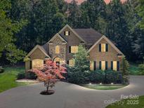 Stunning two-story brick home featuring manicured landscaping and inviting curb appeal with a circular driveway at 5955 Mountain Point Ln, Charlotte, NC 28216