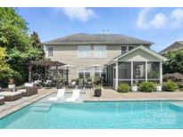 Inviting backyard featuring a sparkling pool, lounge chairs, and an outdoor living area perfect for relaxation at 606 Vega Nw St, Concord, NC 28027