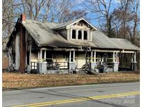 Damaged two-story home with covered front porch and visible fire damage at 619 N Main St, Landis, NC 28088