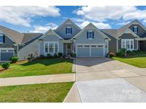 Charming single-Gathering home featuring a well-maintained lawn and two-car garage on a sunny day at 8516 Profit Ln, Charlotte, NC 28215