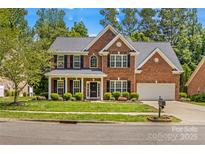 Charming two-story brick home with well-manicured lawn, black shutters, and inviting front entrance at 1011 Wadsworth Ln, Indian Trail, NC 28079
