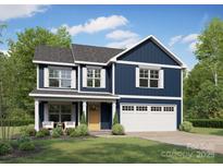 Charming two-story home with blue siding, white trim, and a welcoming front porch at 1016 Forest Dr, Marshville, NC 28103