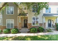 Charming townhome with stone accents, manicured bushes and neutral vinyl siding at 11021 Dundarrach Ln # 40, Charlotte, NC 28277