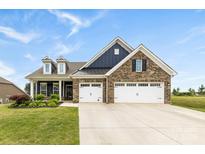 Charming brick home featuring a three-car garage, dormers, and a manicured lawn at 1300 Dali Blvd, Mount Holly, NC 28120