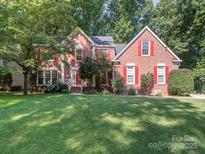 Charming two-story brick home with red shutters and a well-manicured lawn creating a welcoming curb appeal at 13037 Angel Oak Dr, Huntersville, NC 28078