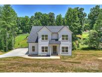 Charming two-story home showcasing classic design, a lush lawn, and a paved driveway, inviting comfort and style at 164 Meadow Glen Dr, Troutman, NC 28166