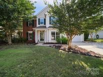 Charming two-story home with landscaped yard, green shutters, and a mix of brick and vinyl siding at 16411 Greybriar Forest Ln, Charlotte, NC 28278