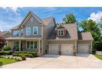 Charming two-story home with a three-car garage, landscaped yard, and inviting front porch at 1805 Trading Path Ln, Waxhaw, NC 28173