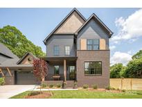 Charming two-story home featuring a brick facade, gray siding, and a covered front porch at 1830 Commodore St, Charlotte, NC 28205
