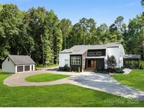 Modern two story home with a circular driveway, garage, and lush landscaping at 202 Walden Ln, Weddington, NC 28104