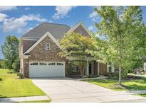 Beautiful two-story home featuring a stone and brick facade, three-car garage, and well-manicured lawn at 2100 Goddard Way, Waxhaw, NC 28173