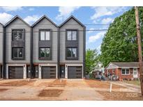 Modern townhomes featuring sleek gray siding and black trim, each with a private garage and a well-manicured lawn at 212 Mattoon St, Charlotte, NC 28216