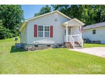 Charming single-story home with a well-maintained lawn, red shutters, and inviting front porch at 219 E Boston Ave # 141516, Bessemer City, NC 28016