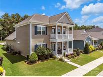 Charming two-story home boasting a double porch, beautiful lawn, and classic architectural details at 282 Harrison Ln, Locust, NC 28097