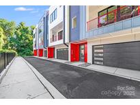 Modern townhome exterior with red accents, featuring garages and contemporary design elements at 412 State St, Charlotte, NC 28208