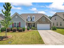 Charming single-Gathering home featuring a manicured lawn, stone accents, and an attached two-car garage at 9547 Horsebit Ln, Concord, NC 28027