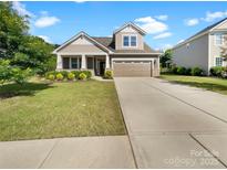 Charming home featuring a well-manicured lawn, neutral color palette, and a two-car garage at 1332 Kings Grove Dr # Lot 18, York, SC 29745