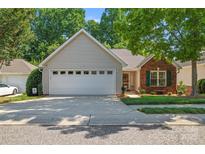 Charming home with a two-car garage, brick facade, manicured lawn, and inviting curb appeal at 210 Oak Village Pkwy, Mooresville, NC 28117