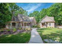 Inviting home with stone and siding, a covered porch, and a walkway leading to the entrance at 3408 Sandalwood Ln, Waxhaw, NC 28173