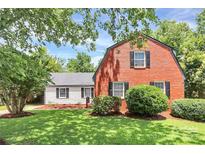 Charming two-story red brick home with a detached garage and lush landscaping at 3909 Woodbriar Trl, Charlotte, NC 28205