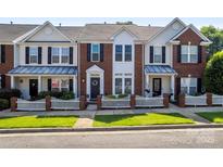 Charming townhome with brick and white siding, a picket fence, and well-manicured lawn at 4103 Christine Ln # E, Waxhaw, NC 28173
