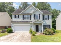 Charming two-story home featuring an attached garage, manicured lawn, and a welcoming entrance at 5233 Halverson Ct, Kannapolis, NC 28083
