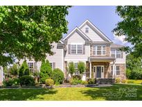 Charming two-story home featuring a well-manicured lawn and beautifully landscaped front yard at 7737 Pleasant Valley Dr, Harrisburg, NC 28075