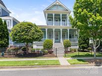 Charming light blue two-story home with double porches, white pillars, and a well-manicured front yard at 8918 Cotton Press Rd, Charlotte, NC 28277