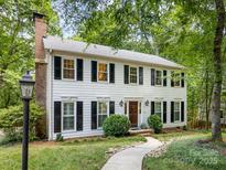 Charming two-story home with black shutters, a brick chimney, and a stone walkway leading to the front door at 1119 Holleybank Dr, Matthews, NC 28105