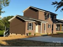 This two-story home features dark siding, black shutters, and a well manicured lawn at 112 Gilliatt St # 1, Shelby, NC 28150