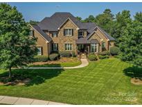 Stunning stone and brick home with lush landscaping and manicured lawn at 1377 Shinnecock Ln, Fort Mill, SC 29707