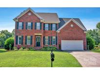 Traditional two-story brick home featuring a well-manicured lawn and a two-car garage at 2117 Copperplate Rd, Charlotte, NC 28262