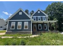 Charming two-story home featuring a covered porch, gray siding, and a well-manicured lawn at 3218 Player Ct, Salisbury, NC 28144